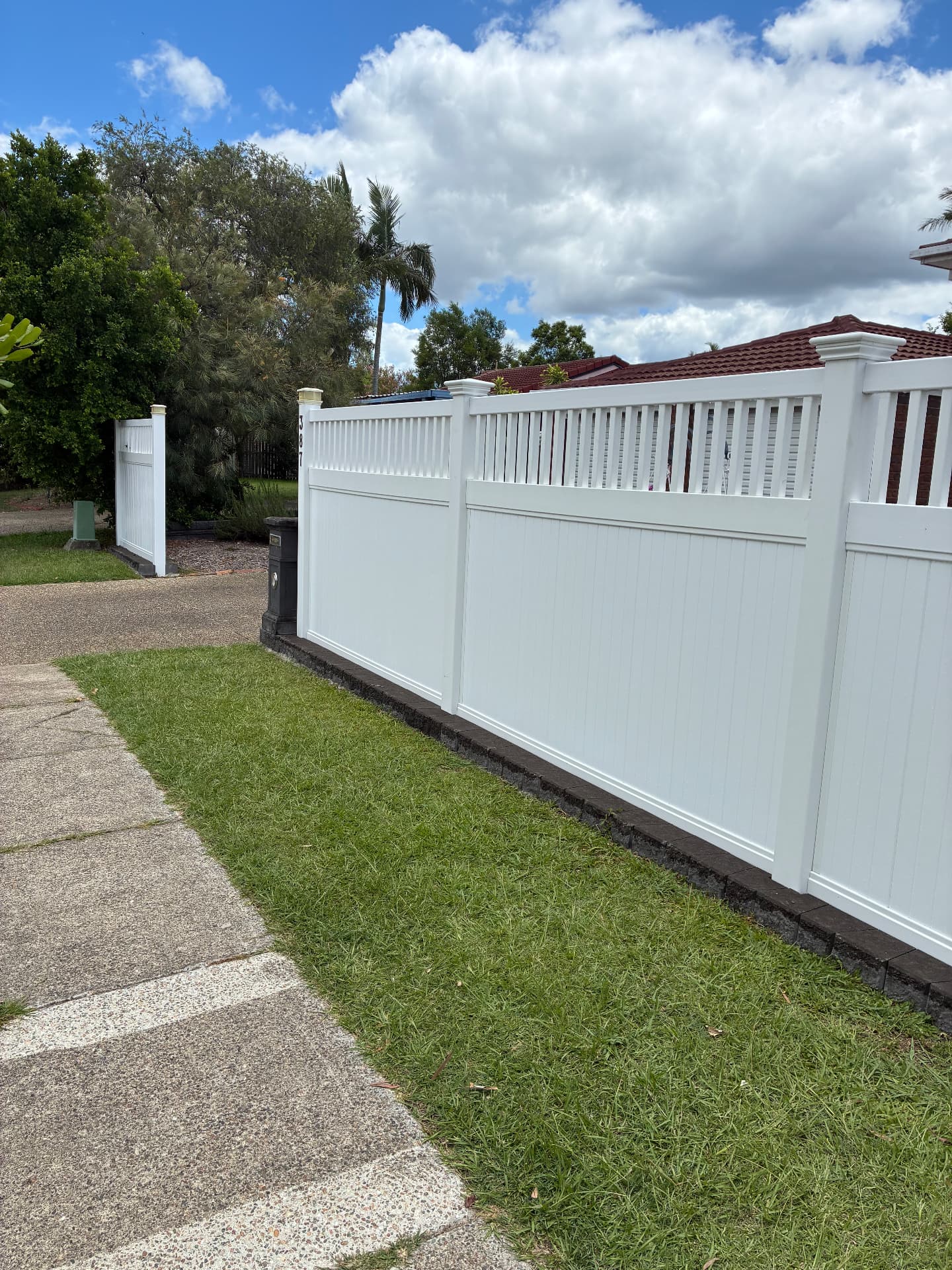 White privacy fence with decorative posts and slats